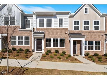 Charming brick townhome exterior with manicured landscaping and inviting entryway at 260 Chesapeake Commons St # 156, Garner, NC 27529