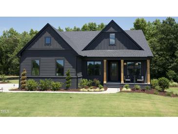 Charming home featuring a dark exterior, well-manicured lawn, and a welcoming front porch with wooden pillars at 306 Golden Leaf Farms Rd, Angier, NC 27501