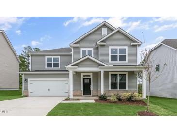 Two-story home with gray siding, white trim, a covered front porch, and an attached two-car garage at 309 Umstead St, Sanford, NC 27330