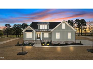 Charming craftsman home featuring stone accents, neutral siding, black metal roof accents, and manicured landscaping at 35 Wheatfield Ln, Youngsville, NC 27596