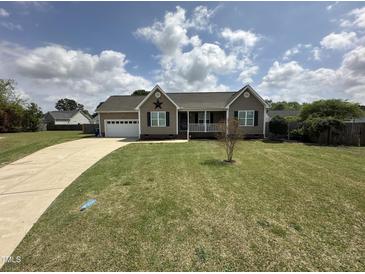 Charming home featuring a manicured lawn and a classic exterior design with an inviting front porch at 106 Bishop Ln, Dunn, NC 28334