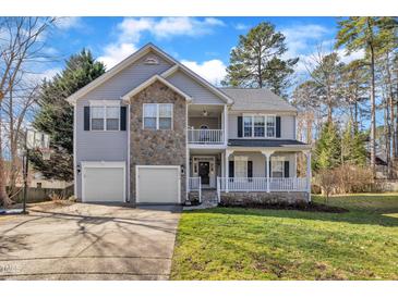 Charming two-story home with stone accents, a two-car garage, and a inviting front porch at 1079 Vauxhall Dr, Apex, NC 27502