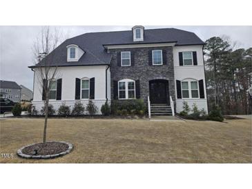 Charming two-story home with stone facade and white painted brick, offering classic elegance at 108 Channel Cove Dr, Holly Springs, NC 27540