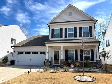 Charming two-story home featuring a well-manicured front yard, two-car garage, and inviting front porch at 1311 Arena Ln, Fuquay Varina, NC 27526