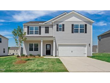 Charming two-story home featuring a two-car garage, landscaped yard, and a welcoming entrance at 156 Paper Birch Way, Fuquay Varina, NC 27526