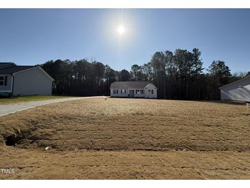 Charming single-story home with a spacious front yard on a sunny day at 209 Magnolia Run Way, Benson, NC 27504