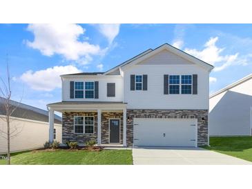 Charming two-story home featuring a brick and vinyl exterior, well-manicured lawn, and two car garage at 276 Hanging Elm Ln, Fuquay Varina, NC 27526