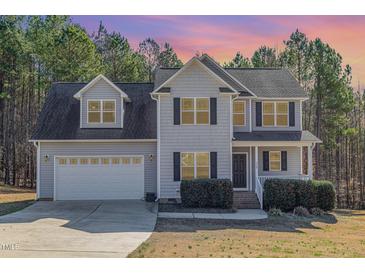 Charming two-story home with a two-car garage, black shutters, and manicured landscaping at 329 Silver Creek Dr, Clayton, NC 27520