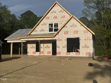 New construction of a home showcasing its framing, brick foundation, and Grip Rite weather barrier at 333 S Main St, Four Oaks, NC 27524