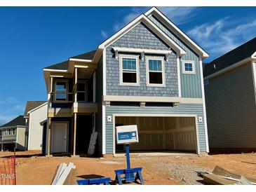 Two-story home showing blue vinyl siding, covered porch, and two car garage at 21 Nimble Way # 176, Clayton, NC 27520