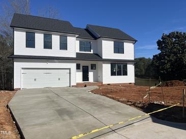 Beautiful two-story home featuring a white siding, black windows, and a large concrete driveway at 3204 Overlook Ct, Burlington, NC 27215