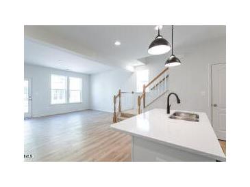 Bright kitchen featuring stainless steel appliances, white cabinets, and an island with pendant lighting at 343 Church St # 66, Wendell, NC 27591