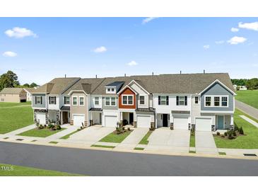 New townhomes featuring modern architecture, attached garages, and lush landscaping at 345 Church St # 65, Wendell, NC 27591