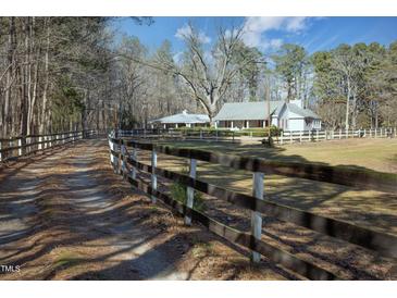 Sprawling country estate with a charming two-story home and a rustic wooden fence at 4100 Durham Rd, Raleigh, NC 27614