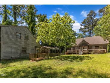 Sprawling backyard with mature trees, two decks and covered parking at 1031 Wait Ave, Wake Forest, NC 27587