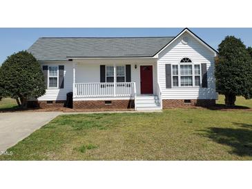 Charming single-story home featuring a welcoming front porch, red door, and well-maintained lawn at 104 Eddy Ct, Benson, NC 27504