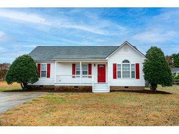 Charming single-story home with red shutters, covered porch, and well-maintained landscaping at 104 Eddy Ct, Benson, NC 27504