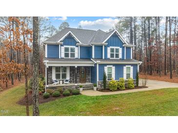 Charming two-story home with a blue exterior, covered front porch, and landscaped yard at 130 Willow Bend Dr, Youngsville, NC 27596