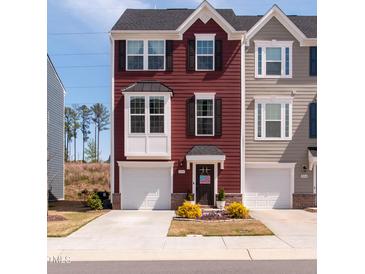 Charming three-story townhouse showcasing beautiful curb appeal and attached one-car garage at 306 Brier Summit Pl, Durham, NC 27703