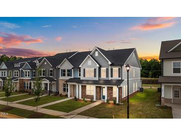 Beautifully landscaped townhome with covered entryway and welcoming brick accents at 945 Alma Railway Dr # 559, Wake Forest, NC 27587