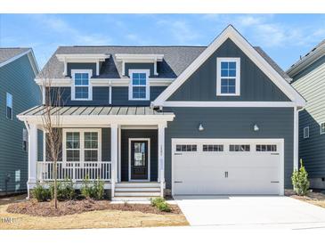 Charming home with a covered porch, two-car garage, and a well-manicured lawn at 1205 Porters Call Dr, Wendell, NC 27591