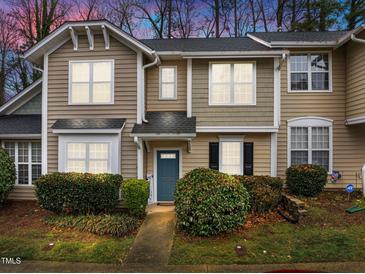 Inviting townhouse with beautiful landscaping, a blue front door, and neutral siding at 2268 Plum Frost Dr, Raleigh, NC 27603
