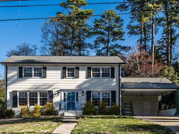 Charming two-story home featuring white siding, black shutters, mature trees, and a convenient attached carport at 304 Northbrook Dr, Raleigh, NC 27609