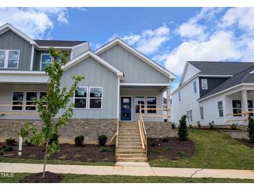 Charming gray two-story home featuring a welcoming front porch with brick base and landscaped front yard at 3928 Willow Gate Way, Raleigh, NC 27604