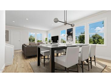 Bright, open-concept dining and living room with stylish furnishings and hardwood floors, and large windows with tree views at 925 Selby Ave, Durham, NC 27713