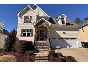 Charming two-story home featuring stone accents, neutral siding, attached garage, and manicured landscaping at 1117 Golden Star Way, Wake Forest, NC 27587