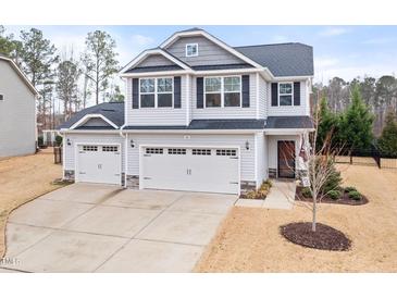 Charming two-story home featuring a two car garage, landscaped yard, and neutral colored siding at 176 E Ravano Dr, Clayton, NC 27527