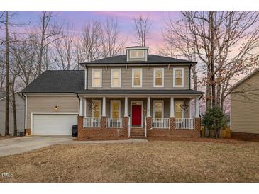 Charming two-story home with a welcoming front porch and red front door at 205 Sarazen Dr, Clayton, NC 27527