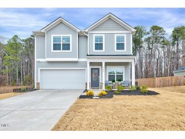 Charming two-story home with gray siding, a two-car garage and meticulously manicured landscaping at 240 Forest Meadow Ln, Franklinton, NC 27525