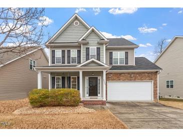 Charming two-story home featuring gray siding, black shutters, covered porch, and attached two-car garage at 4909 Jelynn St, Raleigh, NC 27616