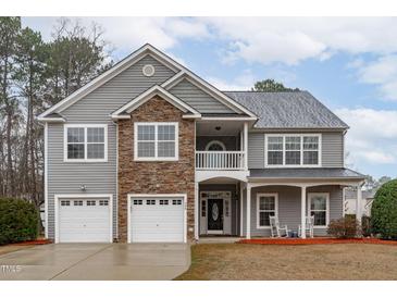 Charming two-story home with stone accents, a two-car garage, and a cozy front porch at 509 Arbor Crest Rd, Holly Springs, NC 27540