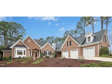 Charming brick home with a well-manicured front yard and a spacious three-car garage at 5204 Winter Holly Ct, Raleigh, NC 27606
