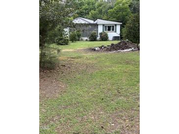 A quaint single story home with a screened in porch and an ample lawn and mature trees at 652 Old Sanford Rd, Moncure, NC 27559