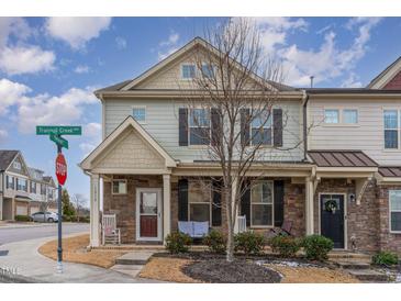 Charming townhome features a stone facade, inviting front porch, and well-manicured landscaping at 1018 Tranquil Creek Way, Wake Forest, NC 27587