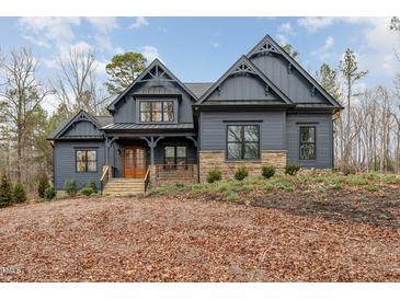 Stunning two-story home featuring stone accents, a covered porch, and professional landscaping at 148 Evington Dr, Pittsboro, NC 27312
