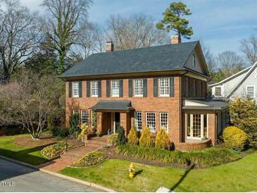Charming two-story brick home with manicured front yard and mature landscaping at 201 W Park Dr, Raleigh, NC 27605