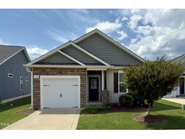Charming single-story home featuring stone accents, a one-car garage, and a well-maintained lawn at 303 Bella Sq, Smithfield, NC 27577