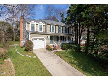 Charming two-story home with a well-manicured lawn, garage and a classic white-railed front porch at 4532 Wingate Dr, Raleigh, NC 27609