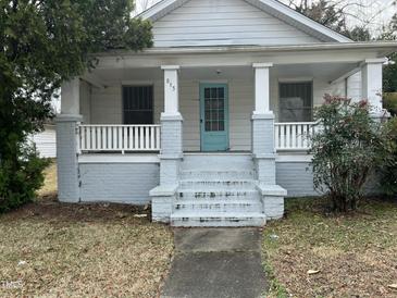 Charming home featuring a quaint front porch with a blue front door at 813 N Main St, Burlington, NC 27217