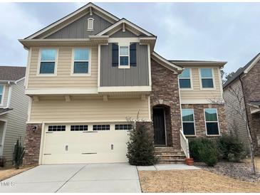 Charming two-story home featuring mixed siding, stone accents, attached garage, and inviting entrance at 1546 Tinos Overlook Way, Apex, NC 27502