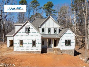 New construction home featuring a classic design, visible framing, and a landscaped front yard at 2410 Carpenter Pond Rd, Raleigh, NC 27613