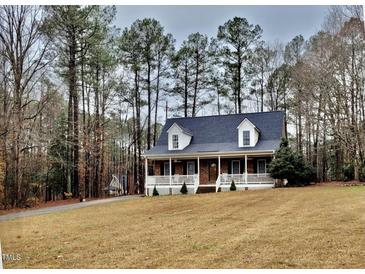 Charming brick home boasts a welcoming front porch and a well-maintained yard surrounded by mature trees at 266 Sagamore Dr, Louisburg, NC 27549