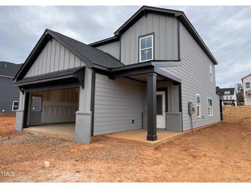 Two-story home featuring a two-car garage, a covered entry, and gray siding with black trim at 4309 Darius Ln # 26, Fuquay Varina, NC 27526