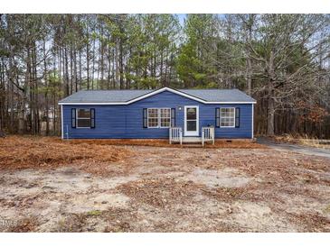 Charming blue home featuring black shutters, white trim, and a neatly maintained front yard at 453 Deer Vw, Sanford, NC 27332