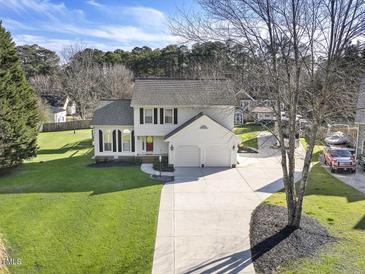 Charming two-story home with well-manicured lawn and a long driveway leading to a two-car garage at 4709 Wyndchase Ct, Fuquay Varina, NC 27526