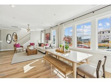 Bright living room with a dining area, large windows, and modern decor; perfect for comfortable living and entertaining at 601 Callan View Ave, Wake Forest, NC 27587